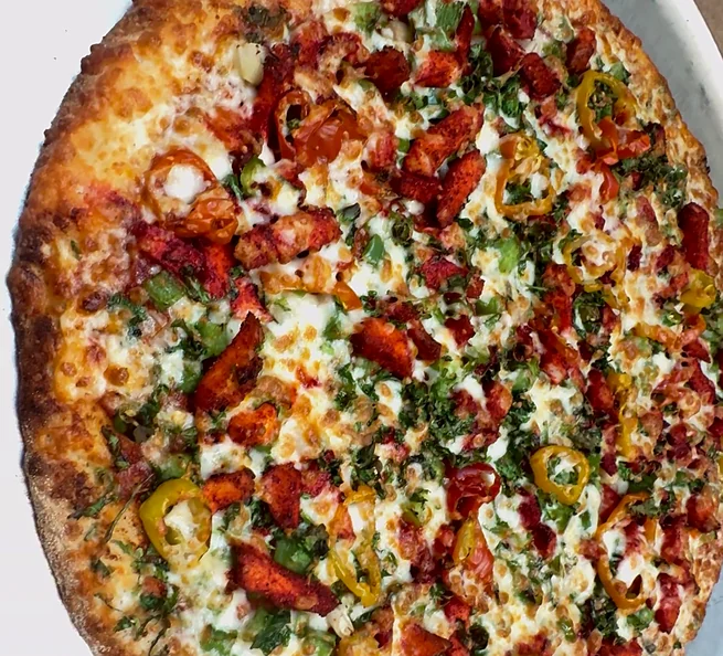 Fresh pizza with red and green peppers and melted cheese