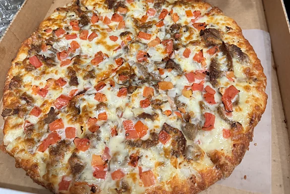 Donair pizza with donair beef and tomato in a pizza box