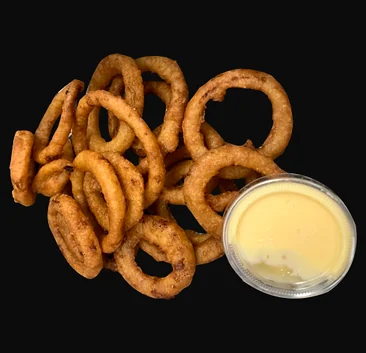 Crispy onion rings with a cup of dipping sauce